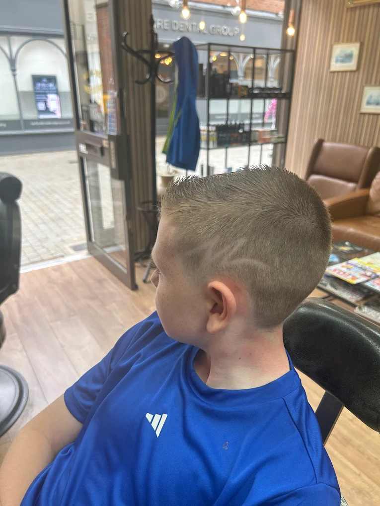 Children's haircut with detailed side design at The Antique Barbers.